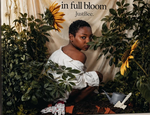 in full bloom album cover: JustBee kneeling in a garden of sunflowers