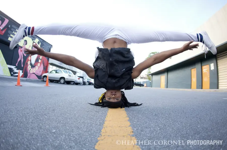 JustBee in a headstand split on a painted road line