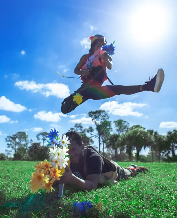 JustBee mid-jump with flowers in the foreground