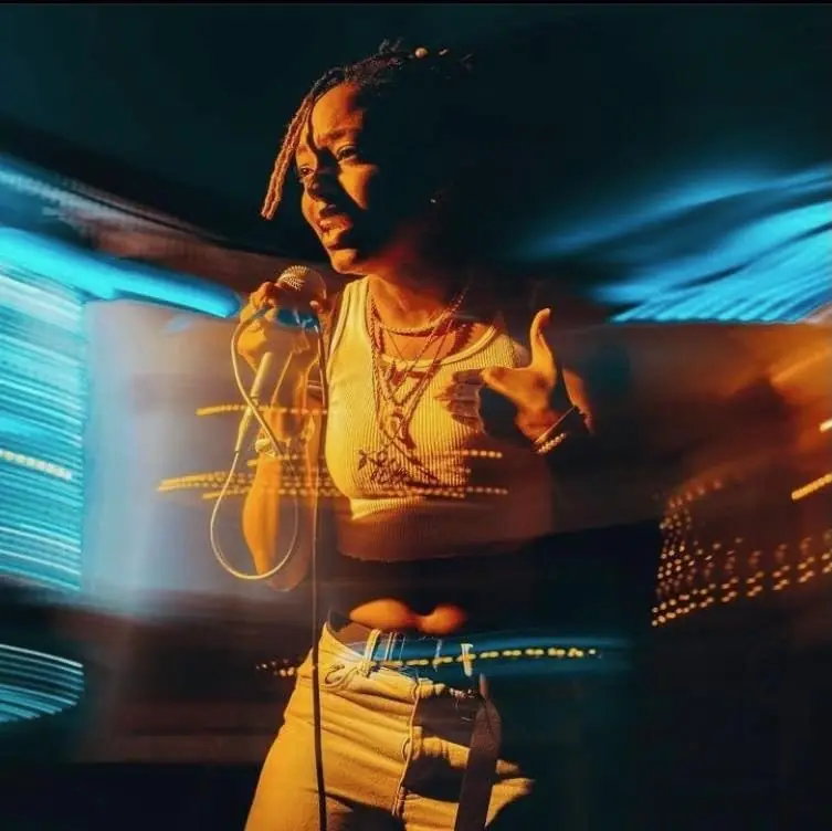 JustBee performing in blue and gold motion blur