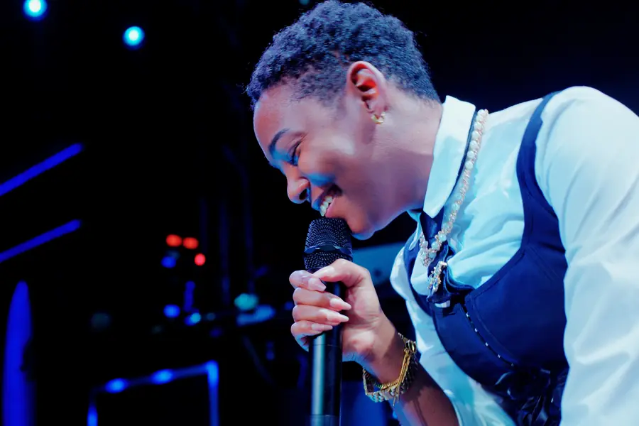 JustBee smiling into the microphone at Sweet Serenade