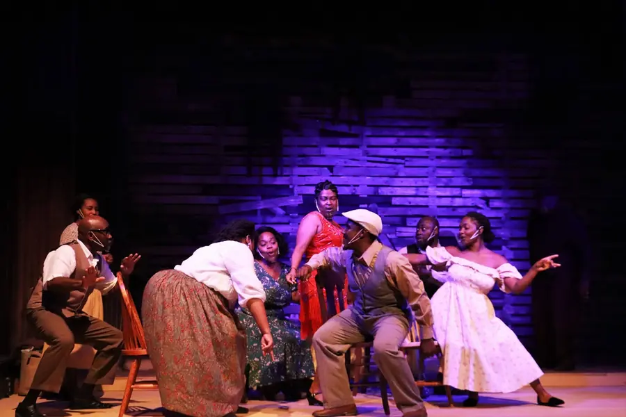 The Color Purple cast mid-number on a purple-lit stage