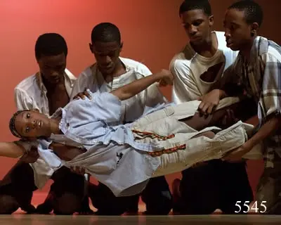 Dancers lifting a performer horizontally in The MAAFA